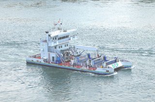 Trash skimming vessel: appears like a blend of a catamaran/double-hulled ship and a barge tug boat.