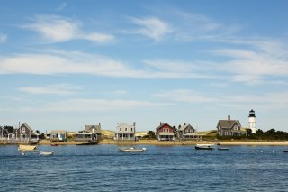 Cape Cod shoreline with homes and people boating.