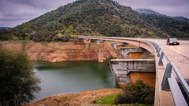 highway over water body, with sky and hill in background