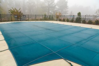 Pool cover over a backyard pool.